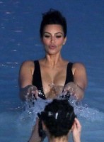 Kim Kardashian flaunts her curves in plunging black swimsuit 